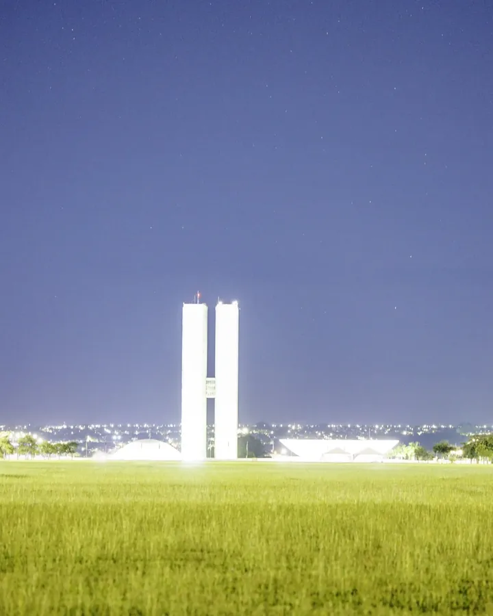 Torres do Congresso iluminadas contra o céu azul antes do amanhecer.